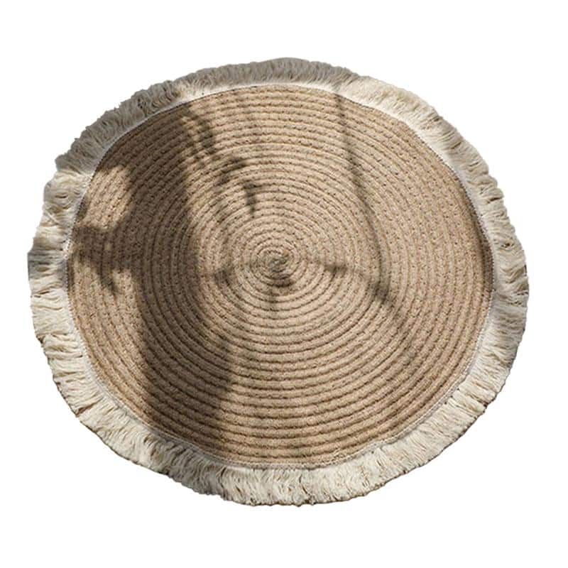 Round woven cotton and linen rug with a cream fringe