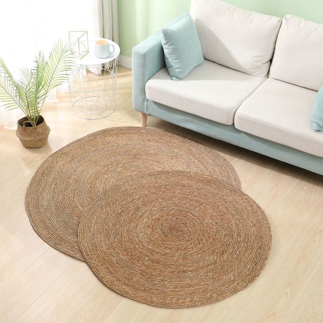 Two round deep brown braided rugs on a light floor