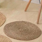 Two round deep brown braided rugs on a light floor