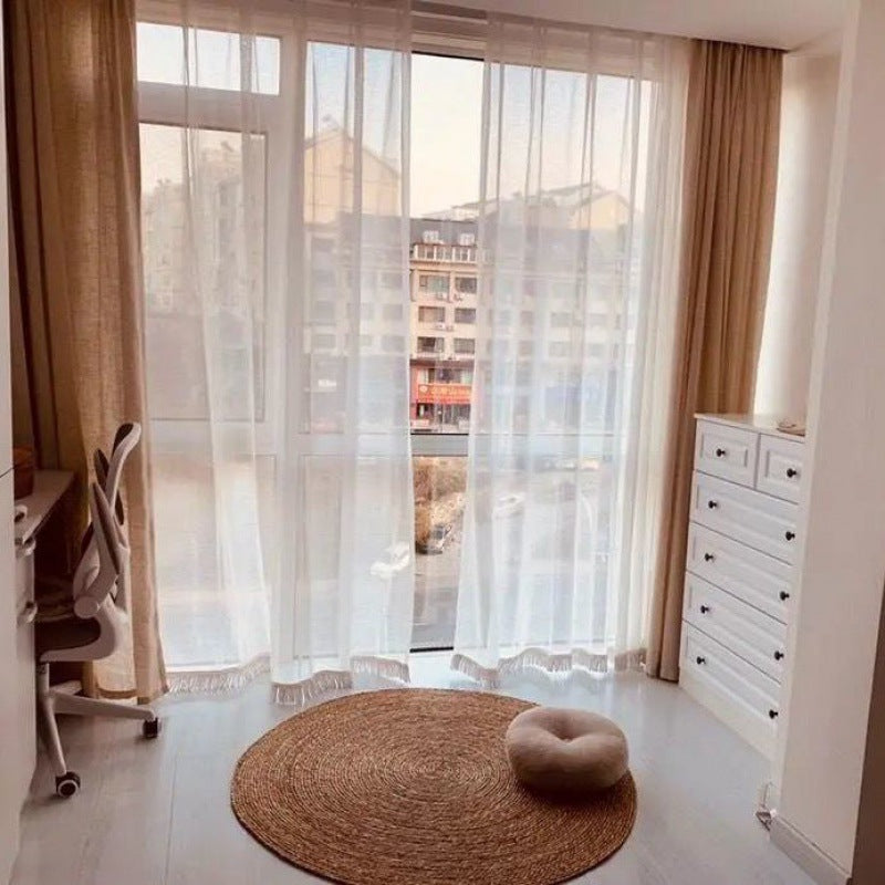 Two round deep brown braided rugs on a light floor