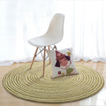 Round sage green and cream braided rug in a bright room