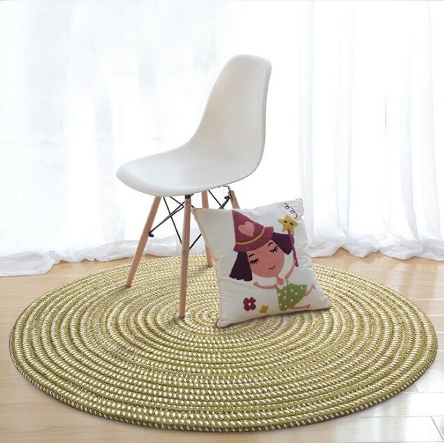 Round sage green and cream braided rug in a bright room