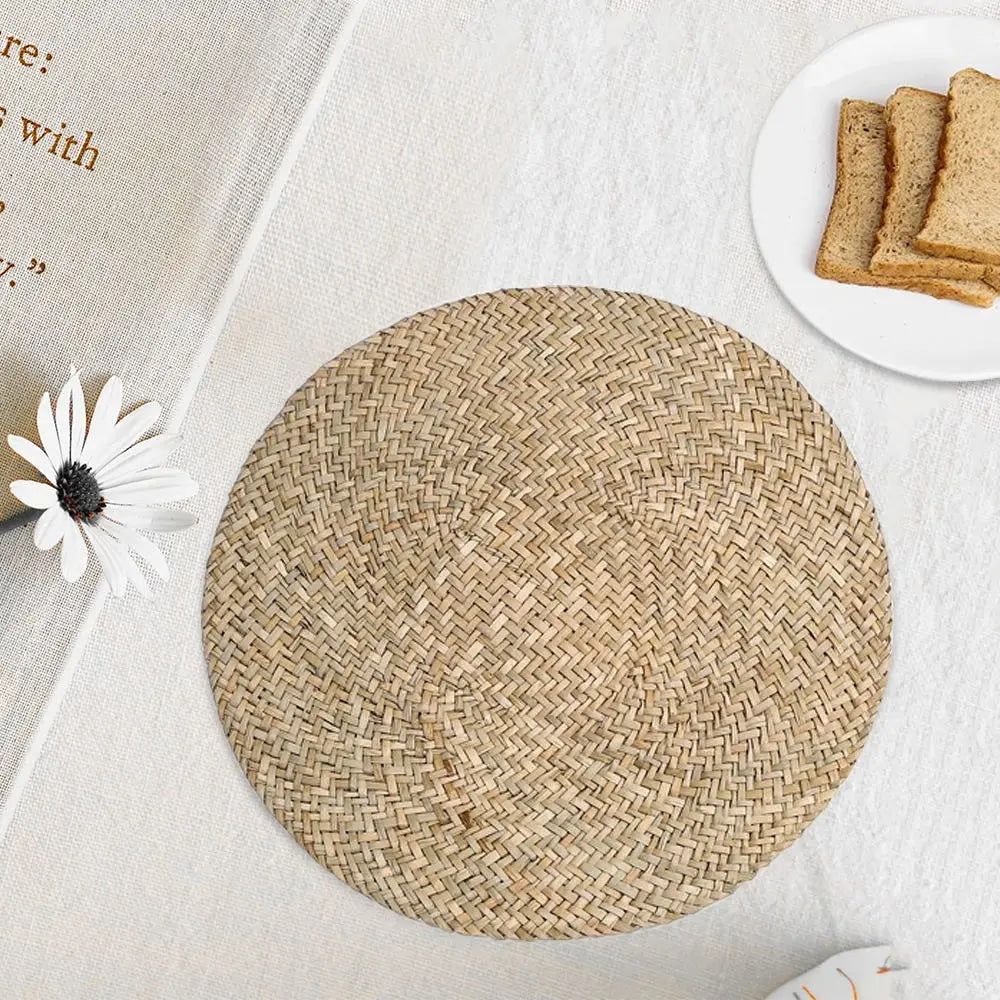 Round placemat hand woven in a tight spiral of natural straw