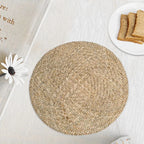 Round placemat hand woven in a tight spiral of natural straw