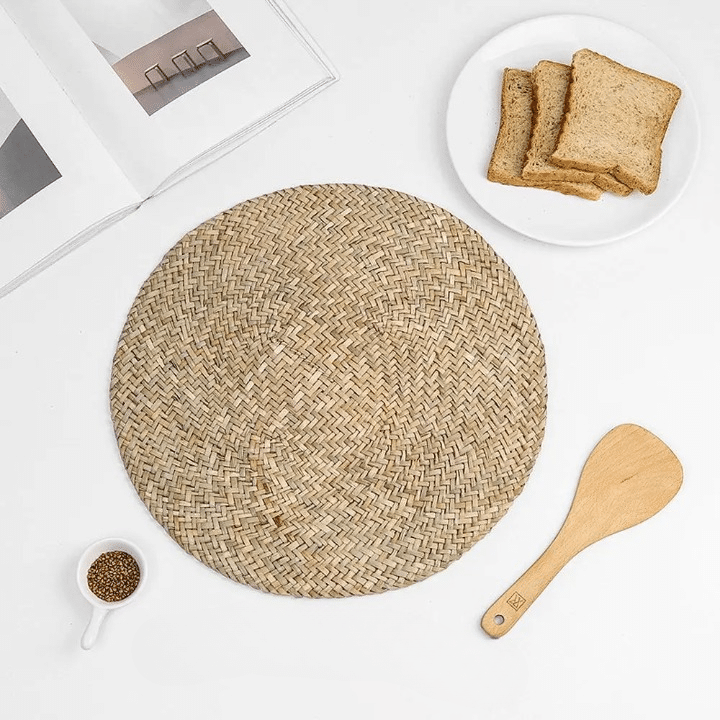Round placemat hand woven in a tight spiral of natural straw