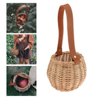 Round woven rattan planter basket with a brown leather look strap