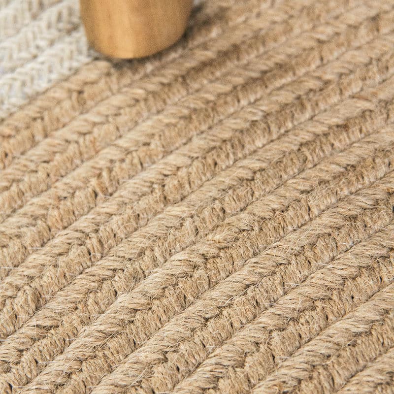 Round jute rug with two white rings under an armchair