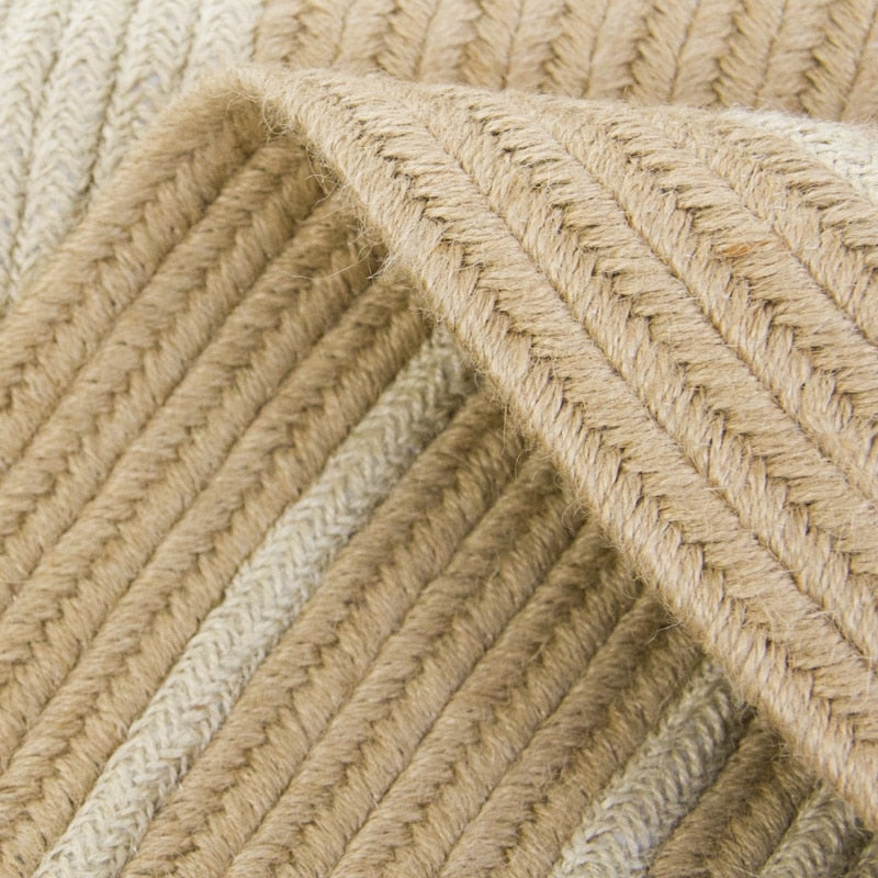 Round jute rug with two white rings under an armchair