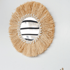 Round mirror framed by a natural fiber fringe
