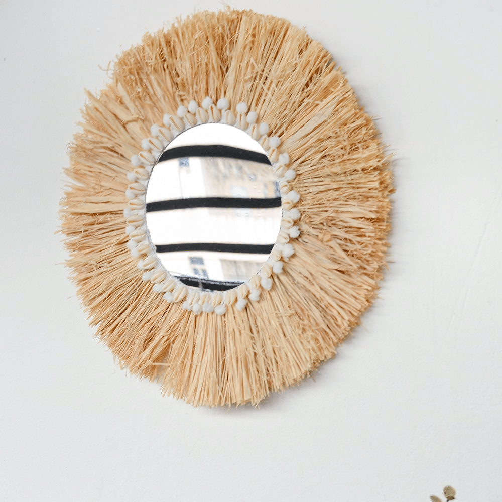 Round mirror framed by a natural fiber fringe
