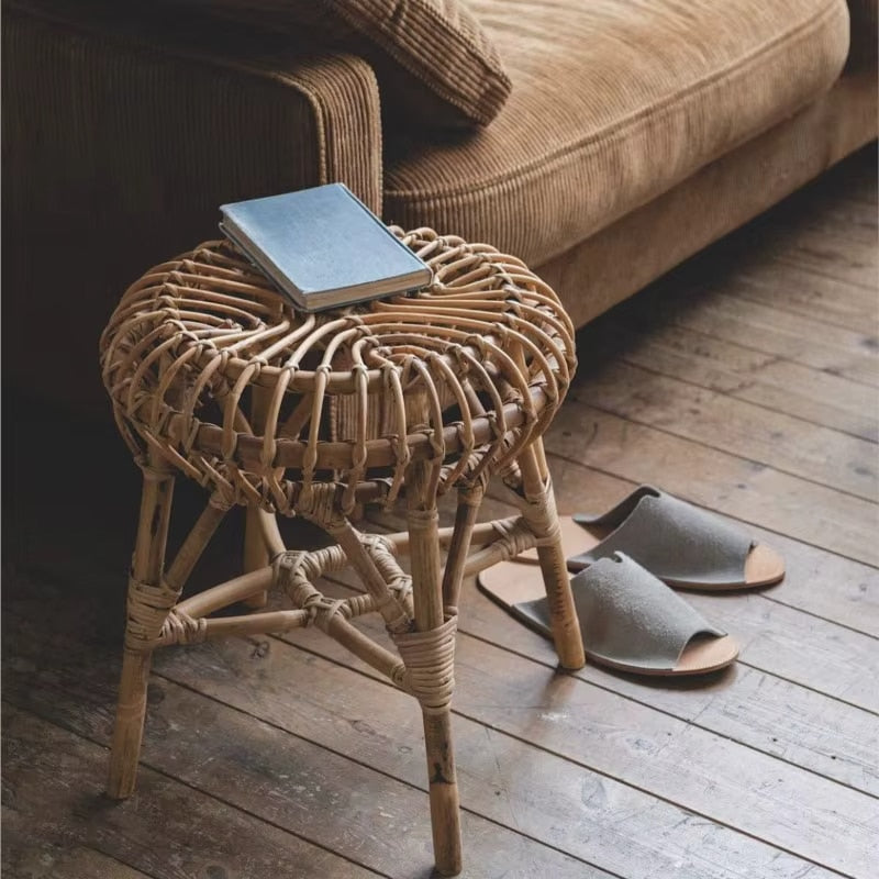 Round hand woven wicker stool with slim legs in a Scandinavian style