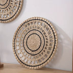 Round openwork woven wall plate with black accents