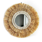Round mirror framed in layered natural straw fringe