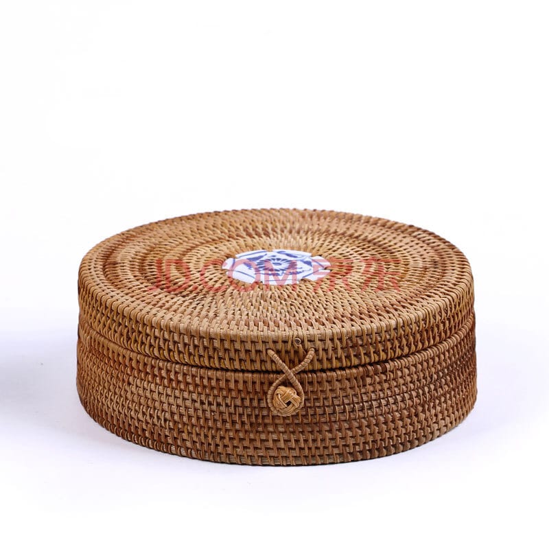 Round woven rattan box with a lid topped by a hand painted ceramic knob