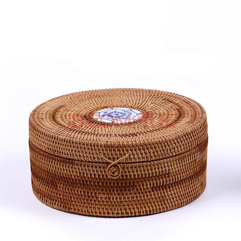 Round woven rattan box with a lid topped by a hand painted ceramic knob