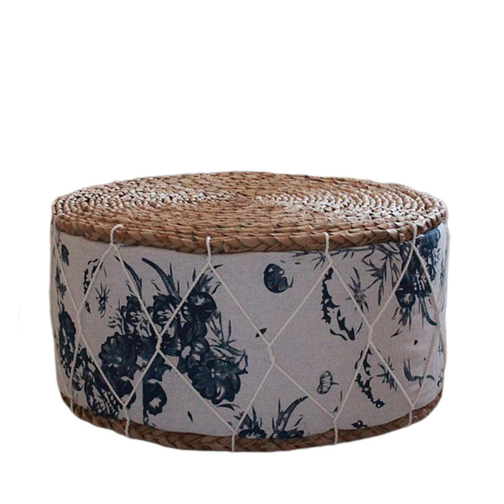 Round rattan pouf with green plant patterns woven on a white ground