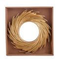 Round mirror framed by swirling rattan rays