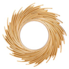 Round mirror framed by swirling rattan rays