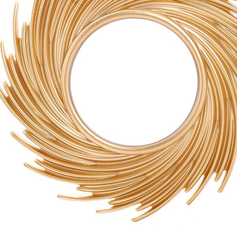 Round mirror framed by swirling rattan rays