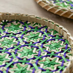 Round woven rattan tray with blue and green geometric pattern
