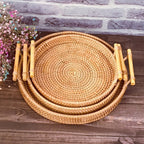 Round rattan serving tray with two light wooden handles