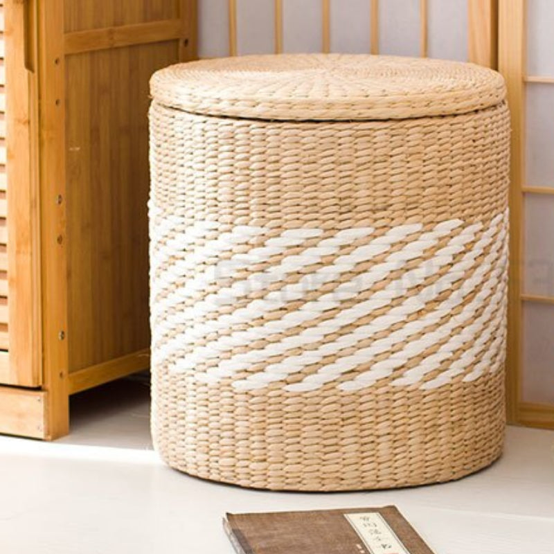 Round hand woven rattan storage stool with white diagonal stripes and a lid