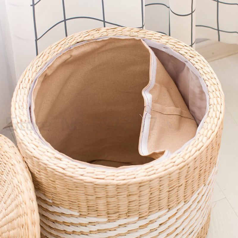Round hand woven rattan storage stool with white diagonal stripes and a lid