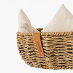 Round wicker dog basket with a cream cushion