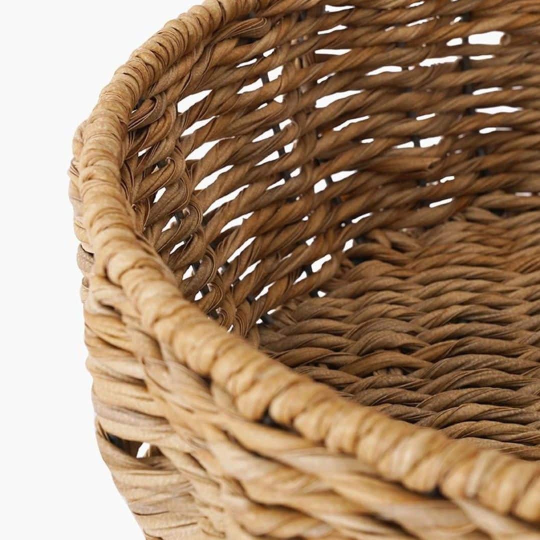 Round wicker dog basket with a cream cushion