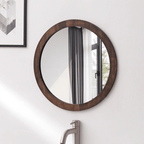 Round wall mirror with a dark wood frame above a sink