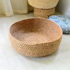 Large round low woven basket with a blue striped cushion