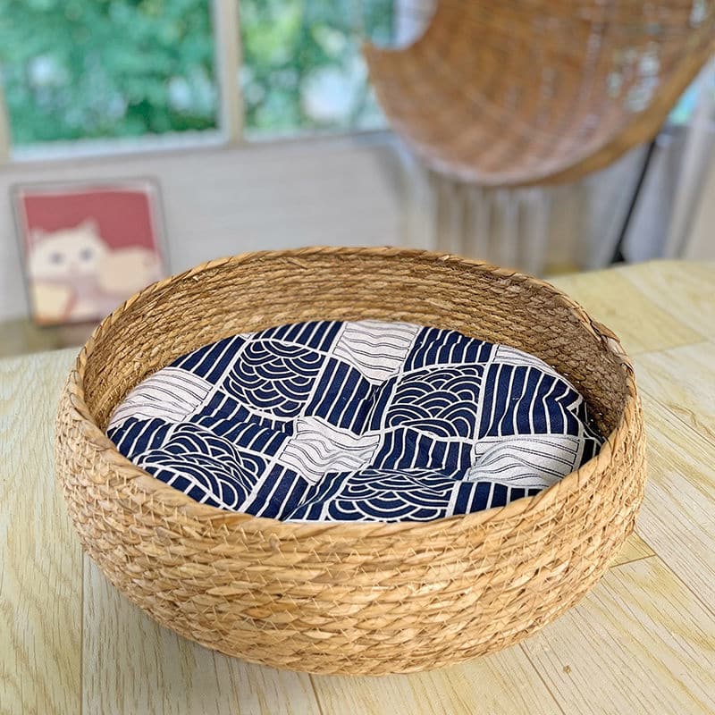 Large round low woven basket with a blue striped cushion