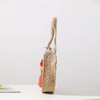 Round hand woven crossbody bag with a textured weave and hand knotted pompoms