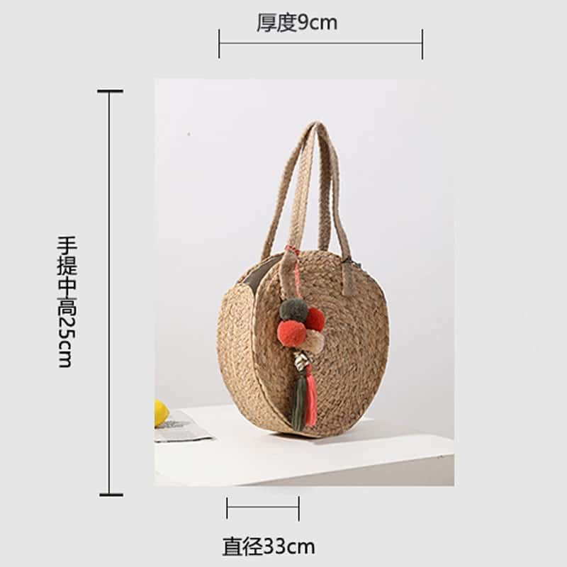 Round hand woven crossbody bag with a textured weave and hand knotted pompoms