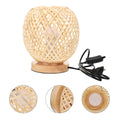 Round bedside lamp with a hand woven rattan shade on a woven base