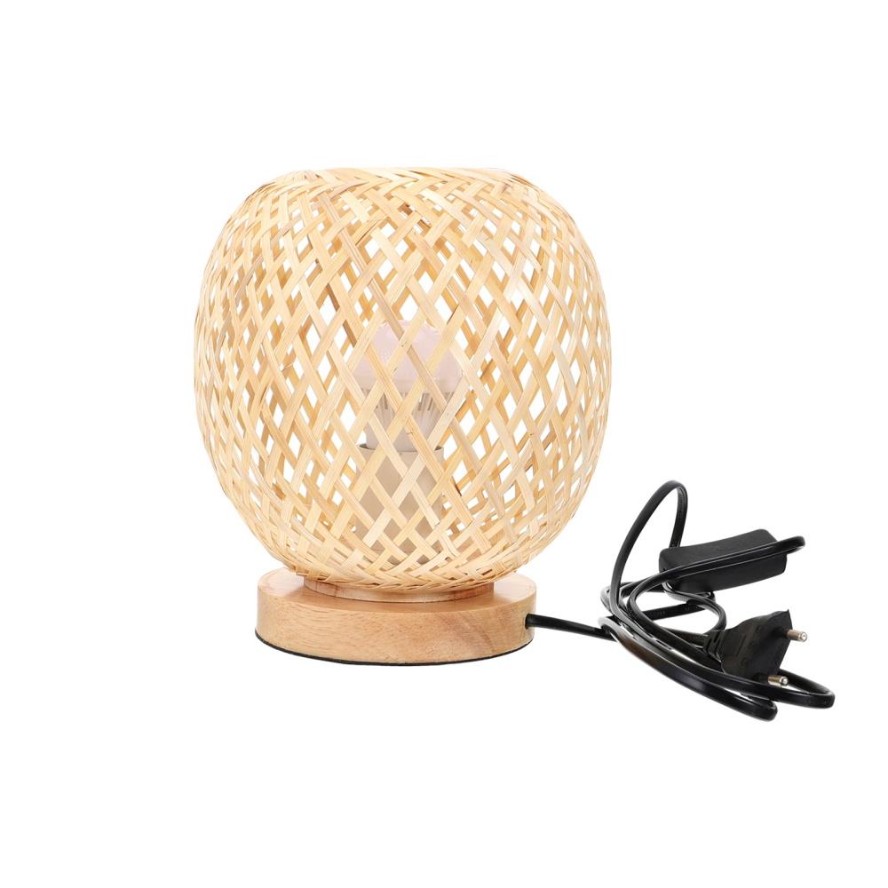Round bedside lamp with a hand woven rattan shade on a woven base