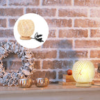 Round bedside lamp with a hand woven rattan shade on a woven base