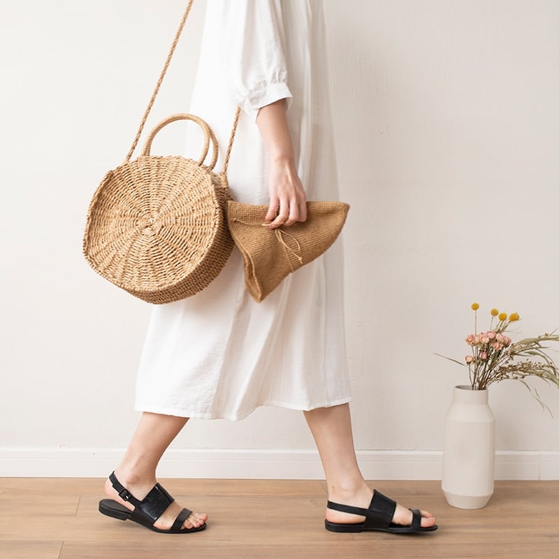 Round hand woven rattan crossbody bag with an adjustable strap in brown or beige