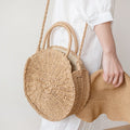 Round hand woven rattan crossbody bag with an adjustable strap in brown or beige