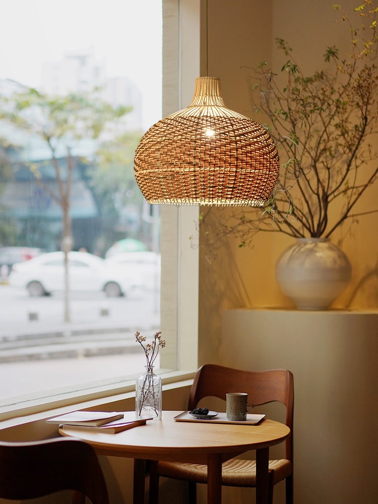 Round woven rattan globe pendant above a dining table