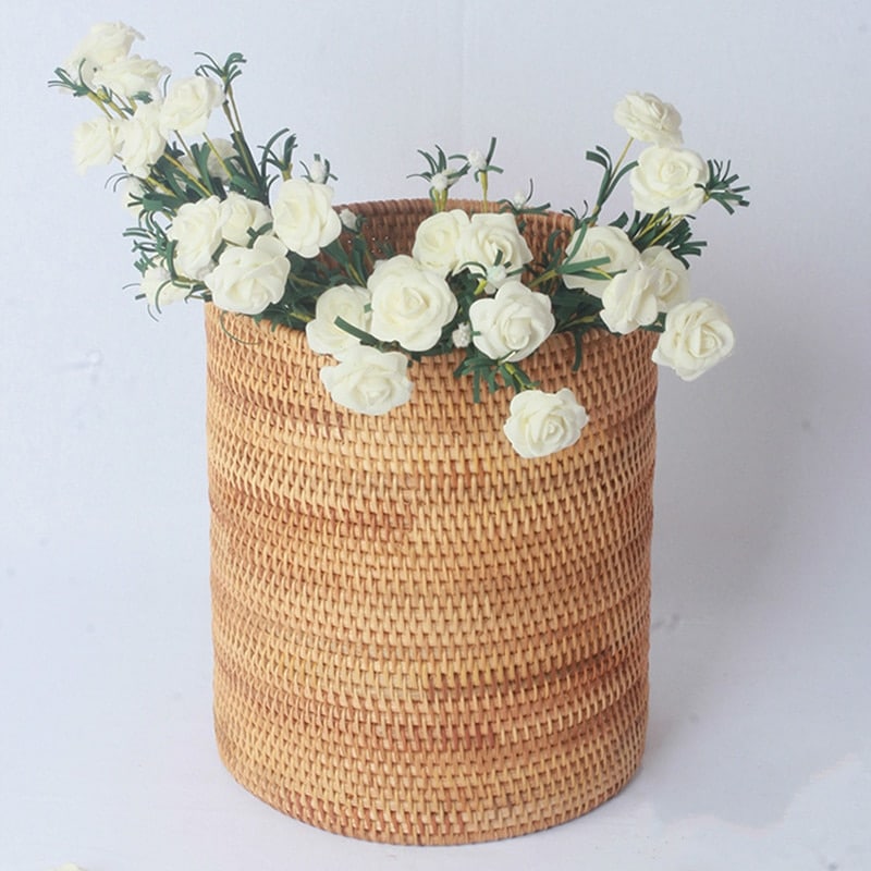 Round straight sided woven rattan bucket holding white flowers