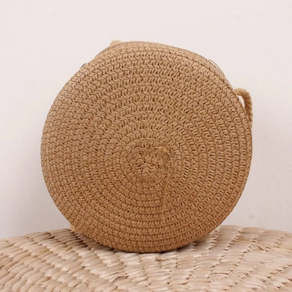 Round brown woven straw crossbody bag worn on the shoulder