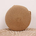 Round brown woven straw crossbody bag worn on the shoulder
