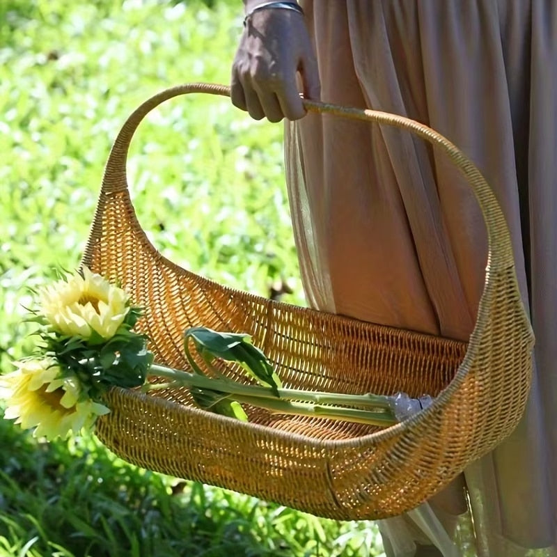 Boat shaped rattan flower basket with tall handle carrying sunflowers