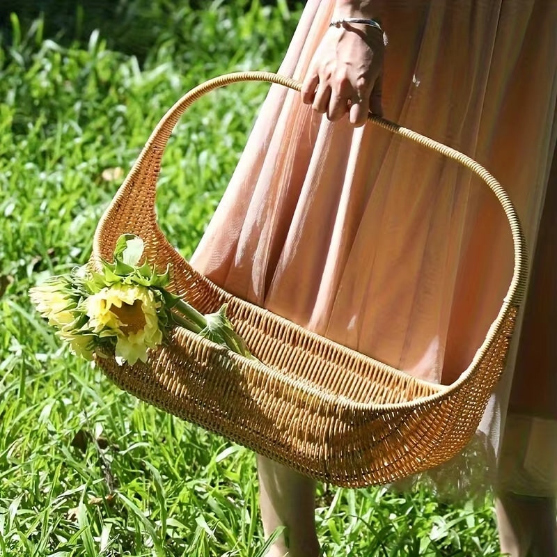 Boat shaped rattan flower basket with tall handle carrying sunflowers