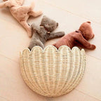 Half moon scalloped rattan wall basket holding plush toys