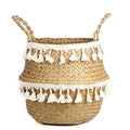 Woven belly basket with two rows of white tassels and handles