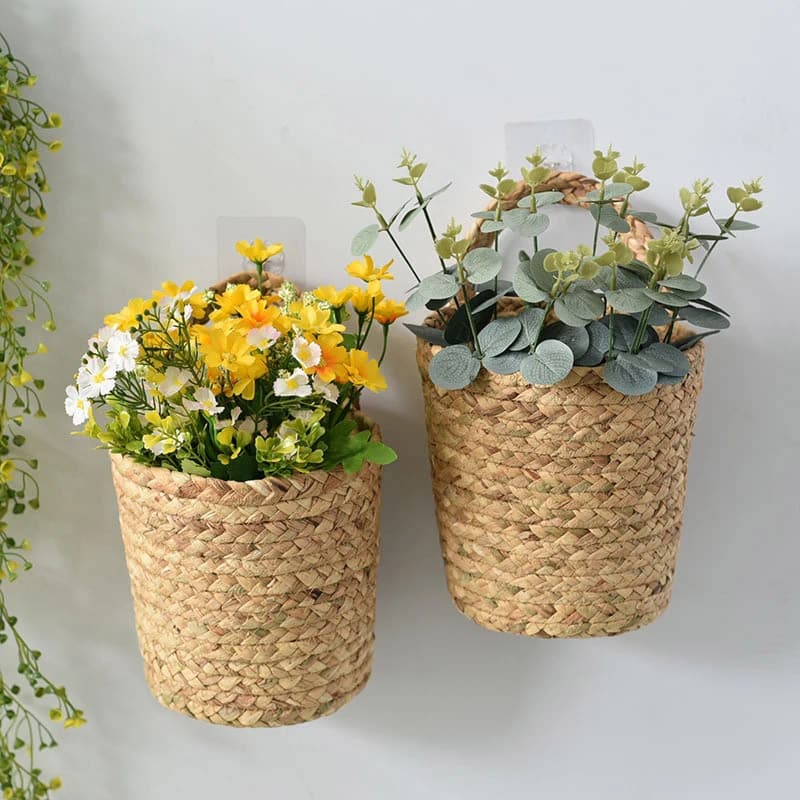 Two natural seagrass wall baskets holding flowers