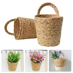 Two natural seagrass wall baskets holding flowers