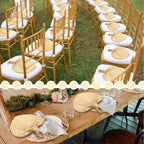 Heart shaped woven hand fans with loop handles set on chairs for a garden wedding